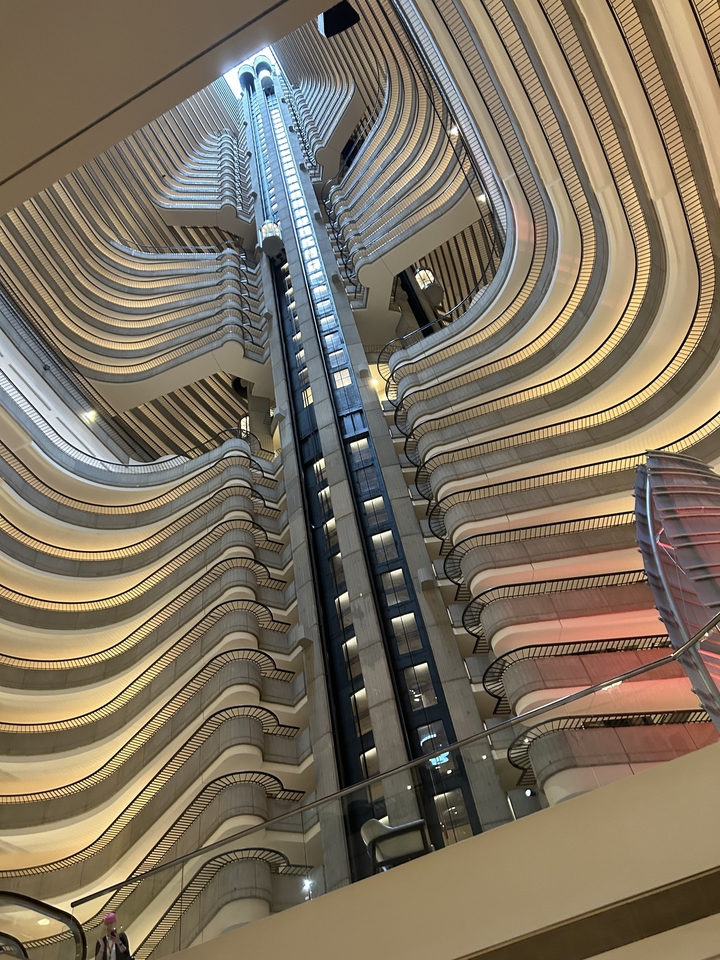 Vue intérieure d'un hôtel avec ascenseurs et balcons.