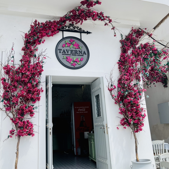 Entrance to a taverna with vibrant flowers.