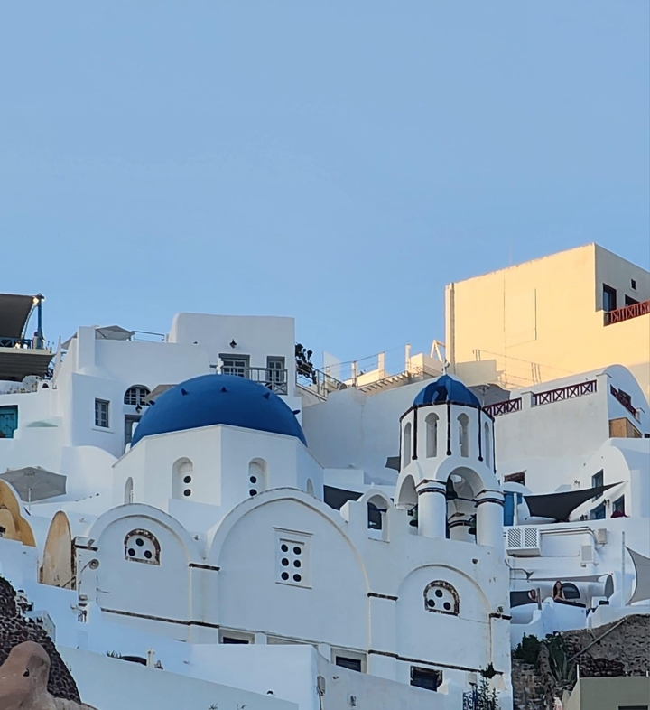 White buildings with blue domes, typical architecture on a sunny day.