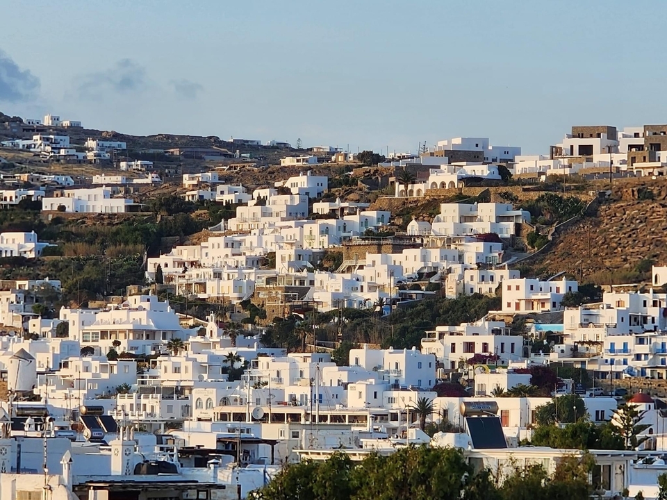 White houses on a hill in early evening light.