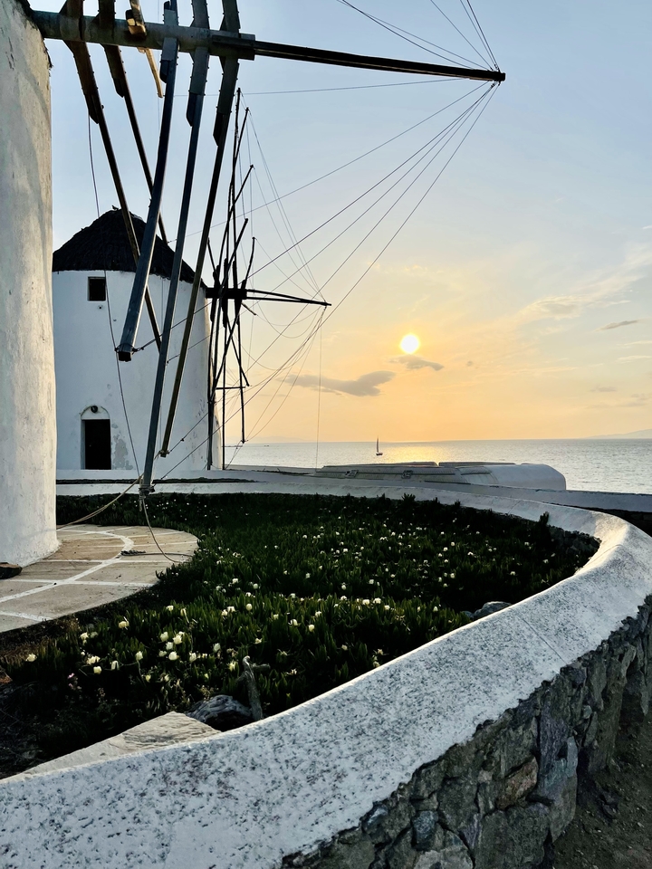 Windmill at sunset with a view of the ocean.