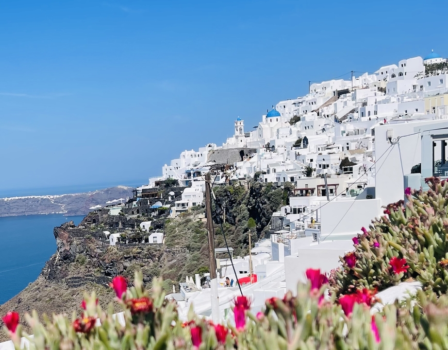 Cliffside village with white buildings overlooking the sea.