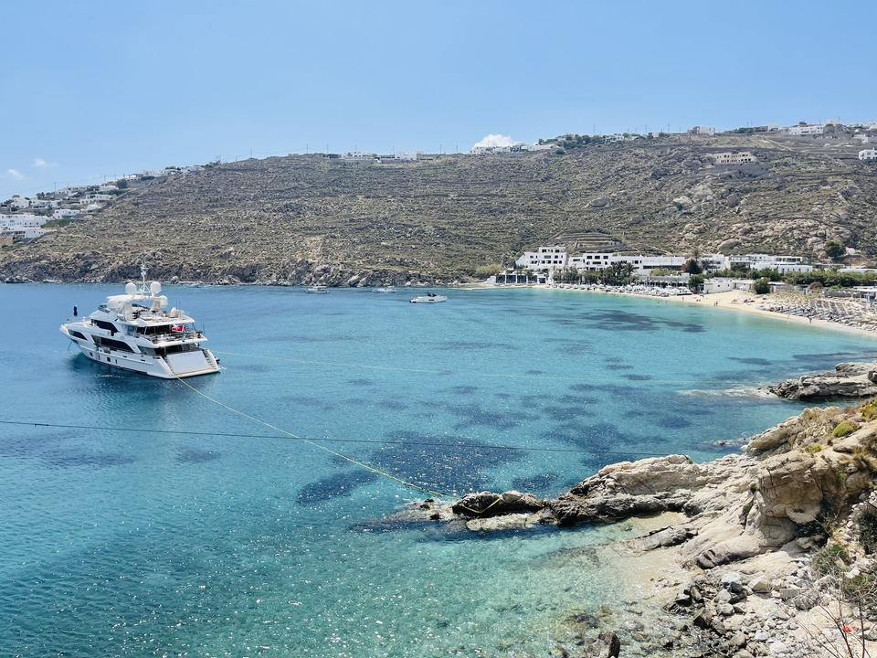 Bay with a yacht anchored and hills in the background.