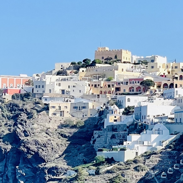 Colorful houses on a hill under a blue sky.