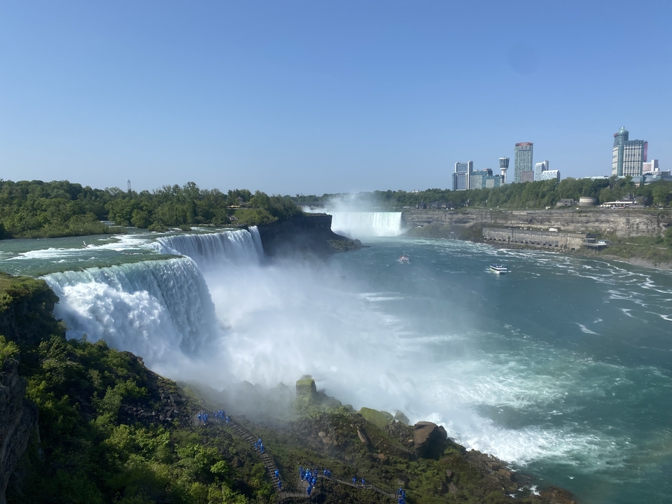 Panoramic view of Niagara Falls with buildings in the distance.