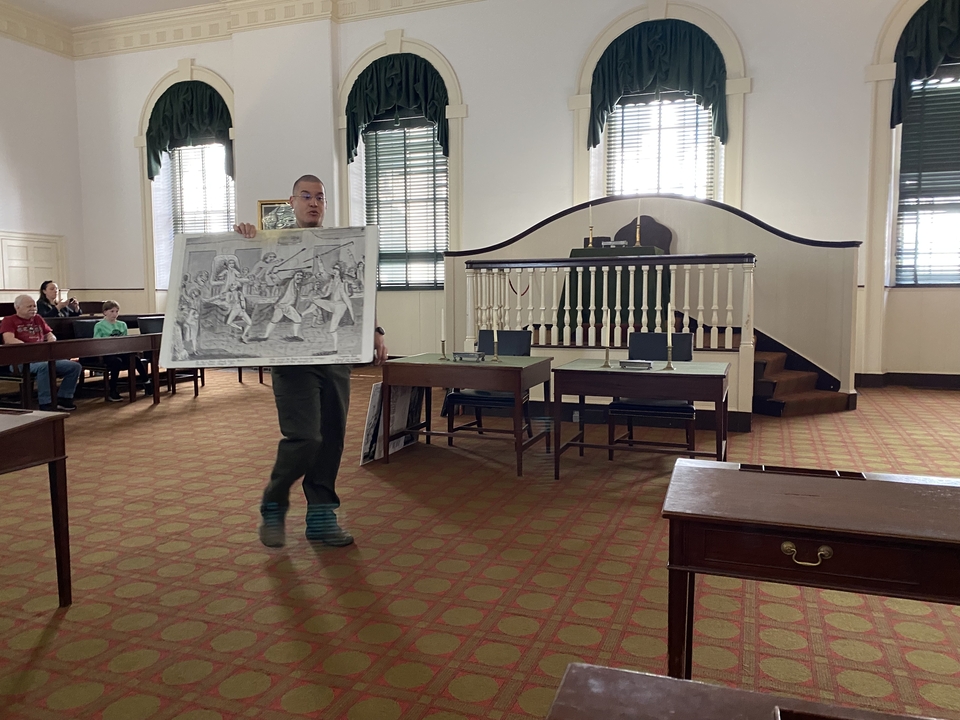 Personne donnant une présentation dans une salle de réunion historique.