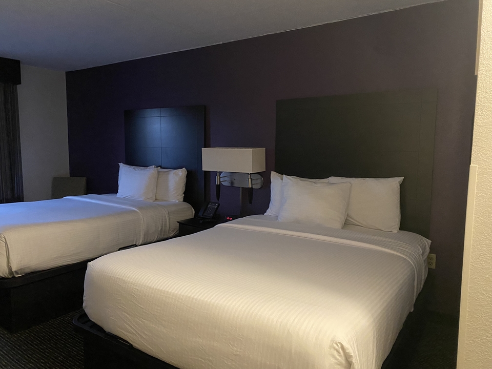 Dark hotel room with two double beds.