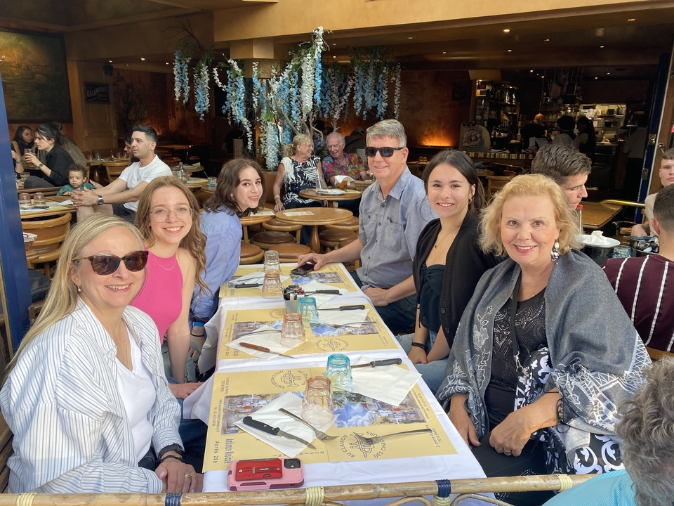 Group of people dining at a restaurant with outdoor seating.