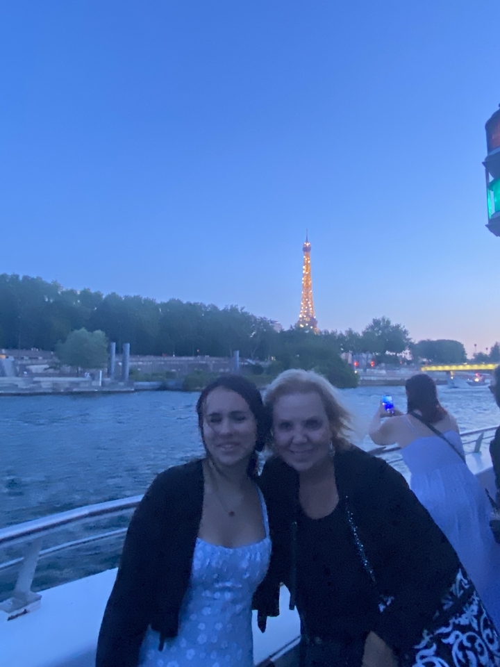 Two people on a river cruise with the Eiffel Tower in the background.