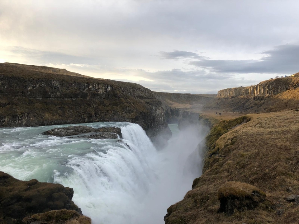 A majestic waterfall with mist and surrounding cliffs