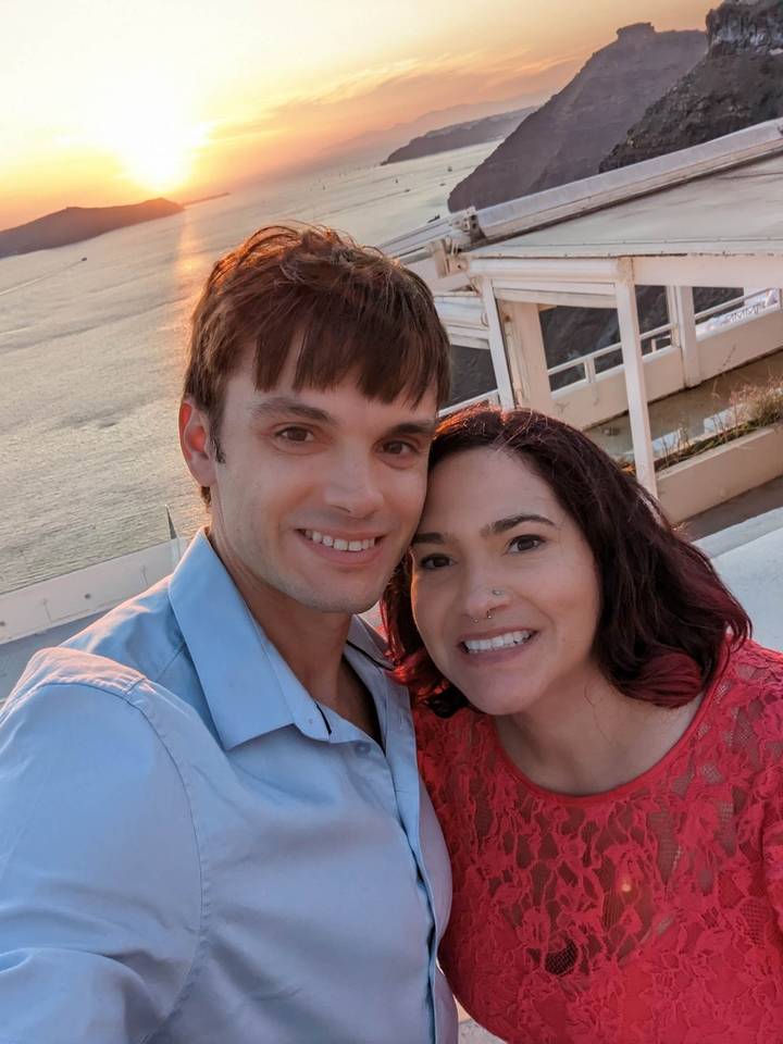 Smiling couple taking a selfie with the sea in the background.