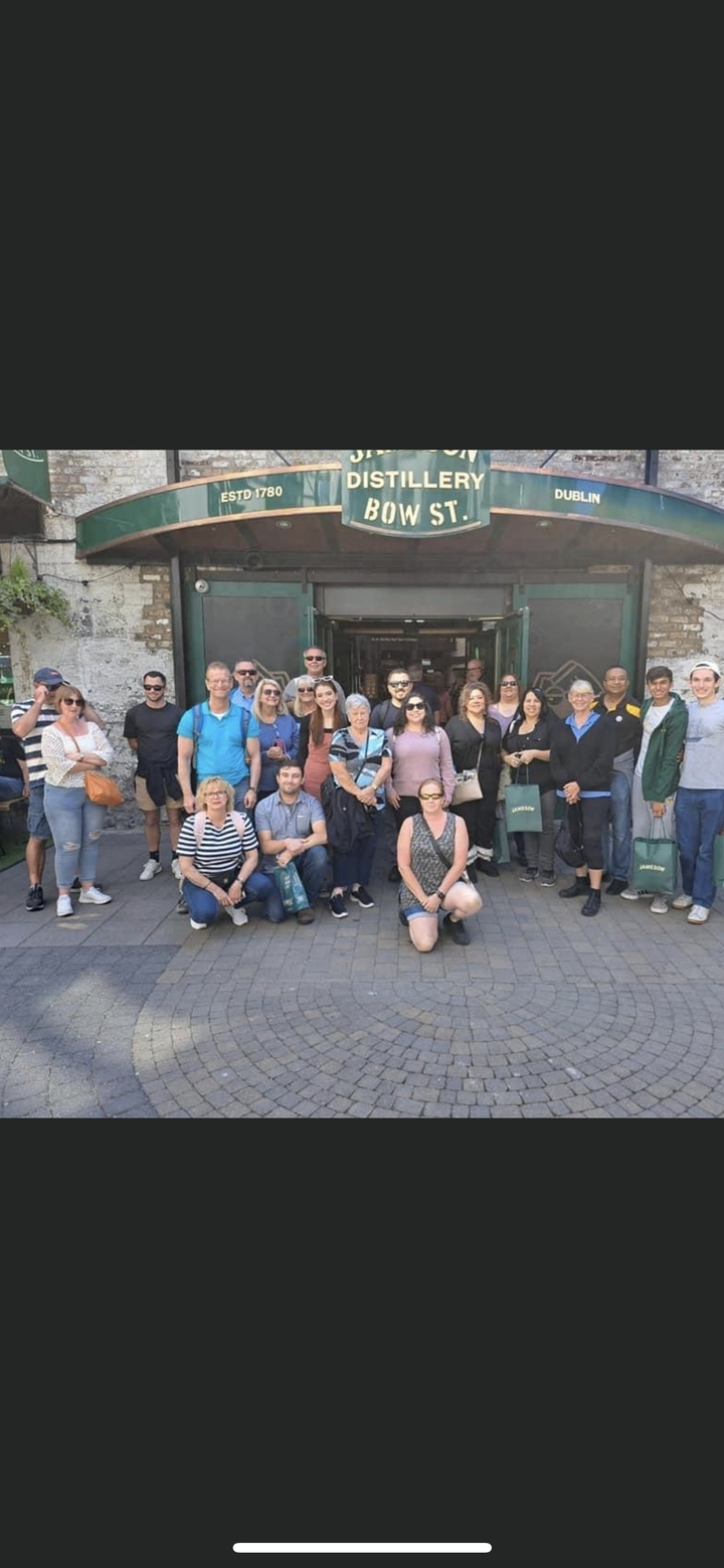 Group of people posing in front of a building entrance.