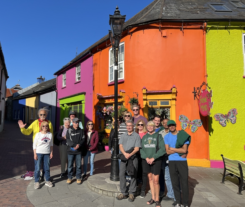 Group of people in front of vibrantly painted houses.