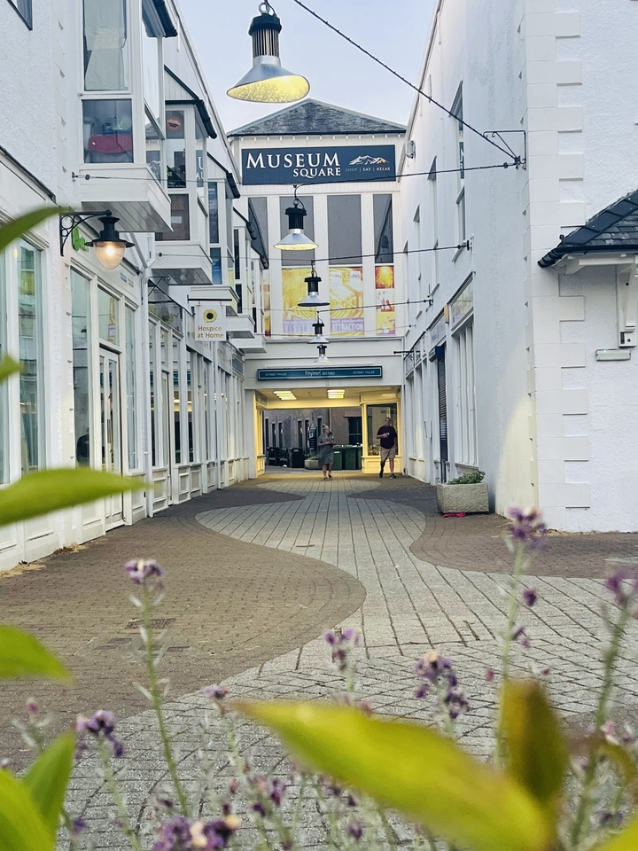 Des gens qui marchent dans un passage avec des murs de verre.