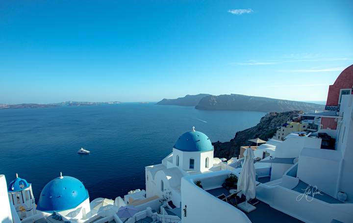 White and blue domed buildings overlooking the sea