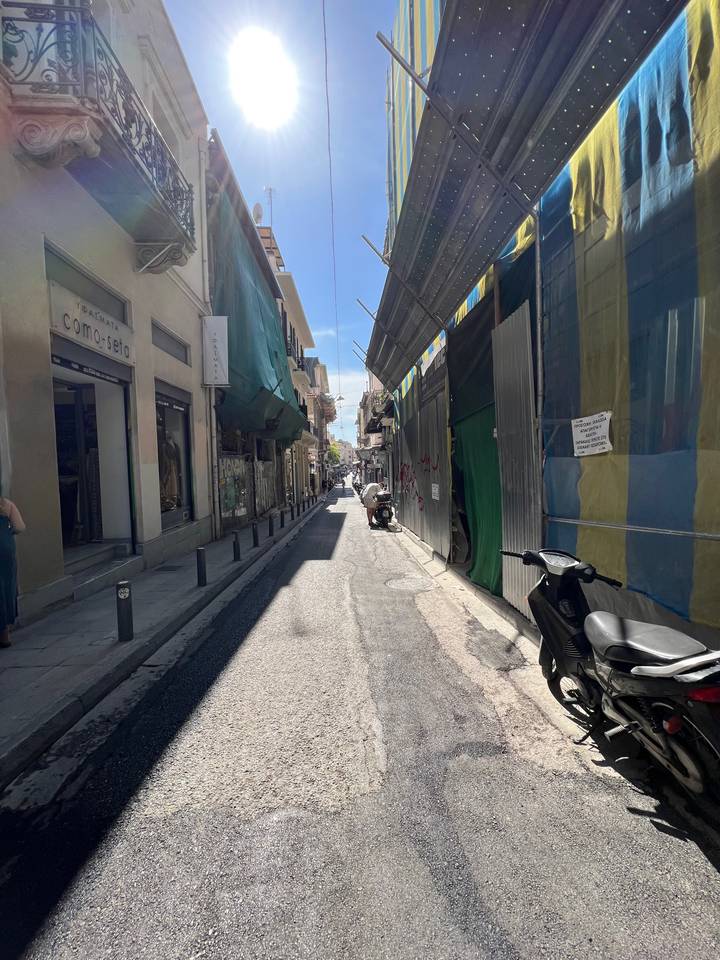 Urban street scene with various storefronts.