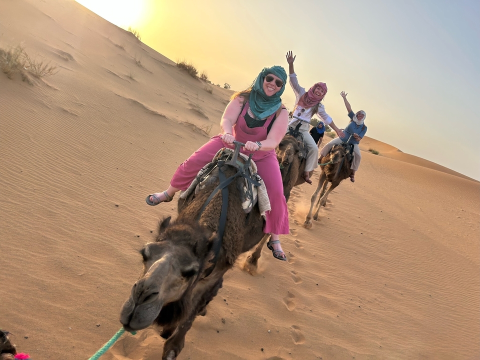 People riding camels celebrating in the desert.