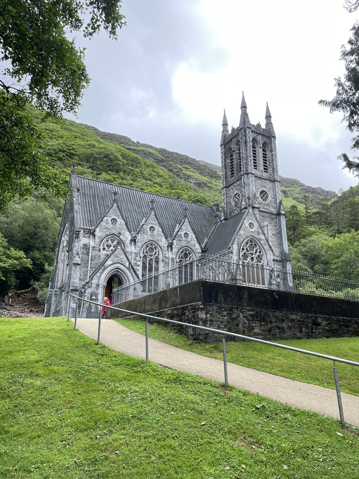 Gothic style church set against a green hillside.