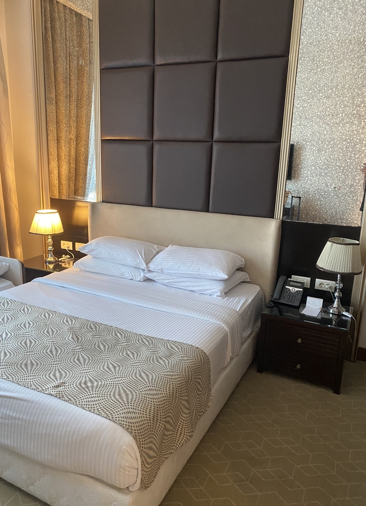 Luxury hotel room with a large bed and warm lighting.
