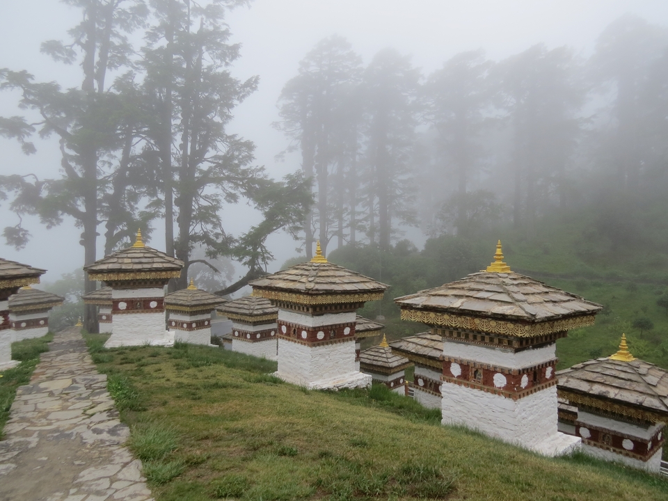 Paysage brumeux avec des chörtens bhoutanais traditionnels.