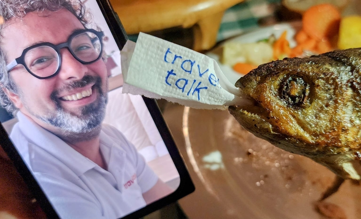 Person holding a piece of paper with a fish.