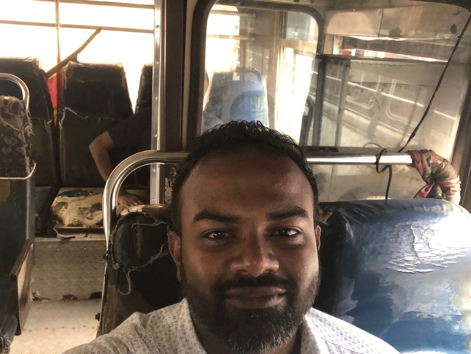 A person on a bus with worn-out seats.