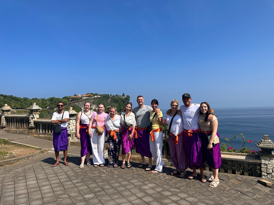 Group standing on a seaside platform with scenic ocean views.