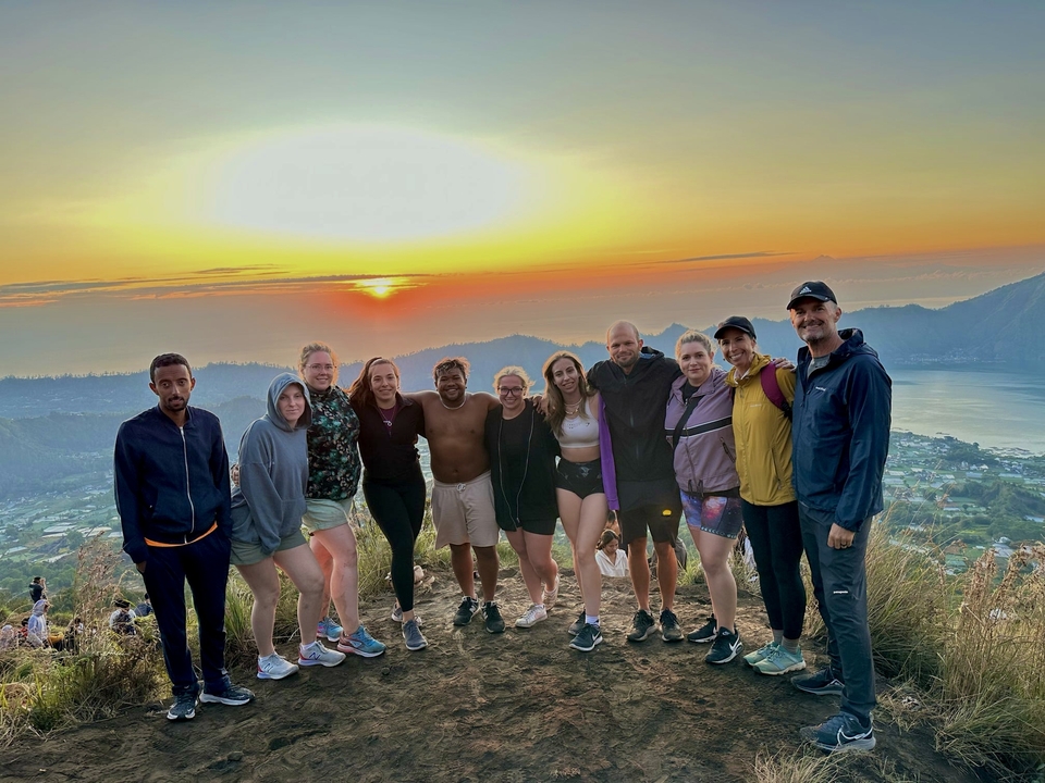 Group enjoying sunrise with scenic valley views.