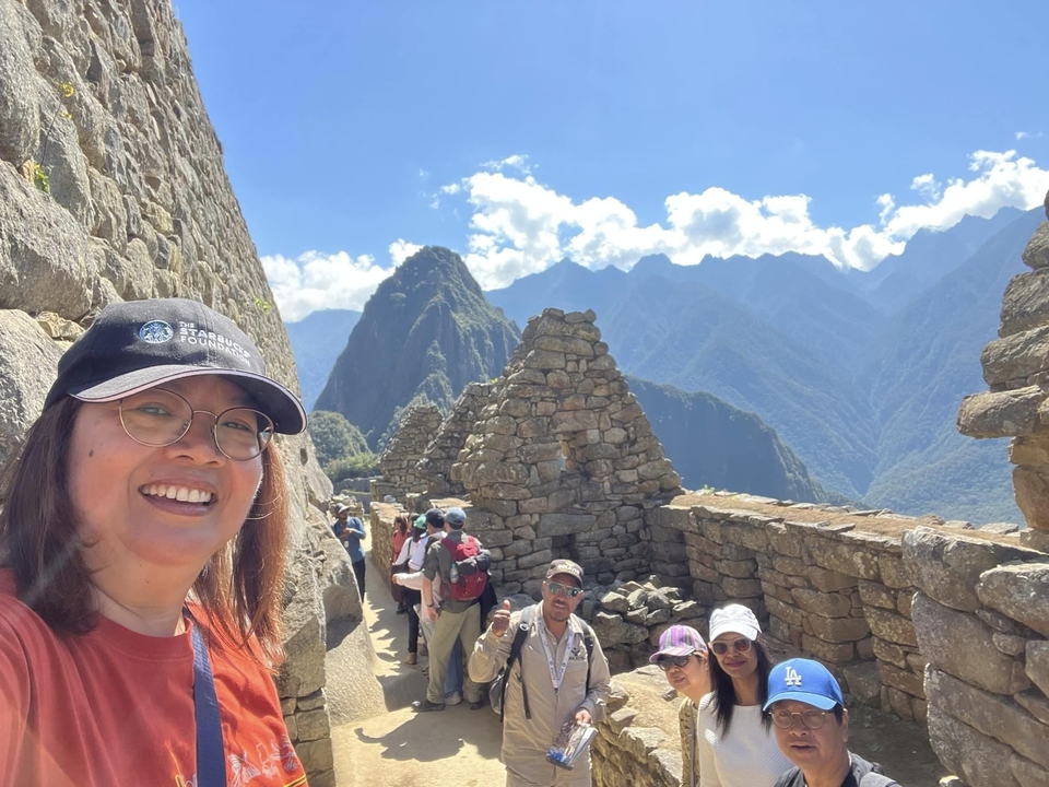 Tourists exploring Machu Picchu with a mountainous backdrop.