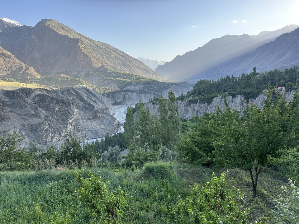 A lush valley with dramatic cliffs and trees.