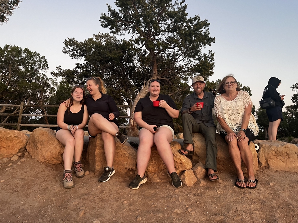 Group of people sitting on rocks, enjoying the view.