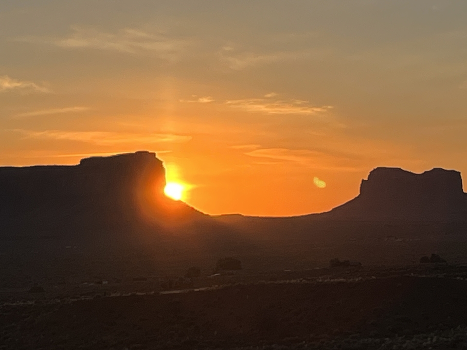 Sunset view over horizon with rocky silhouettes.