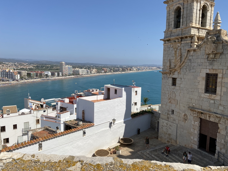 Coastal cityscape with a historic church and the sea.