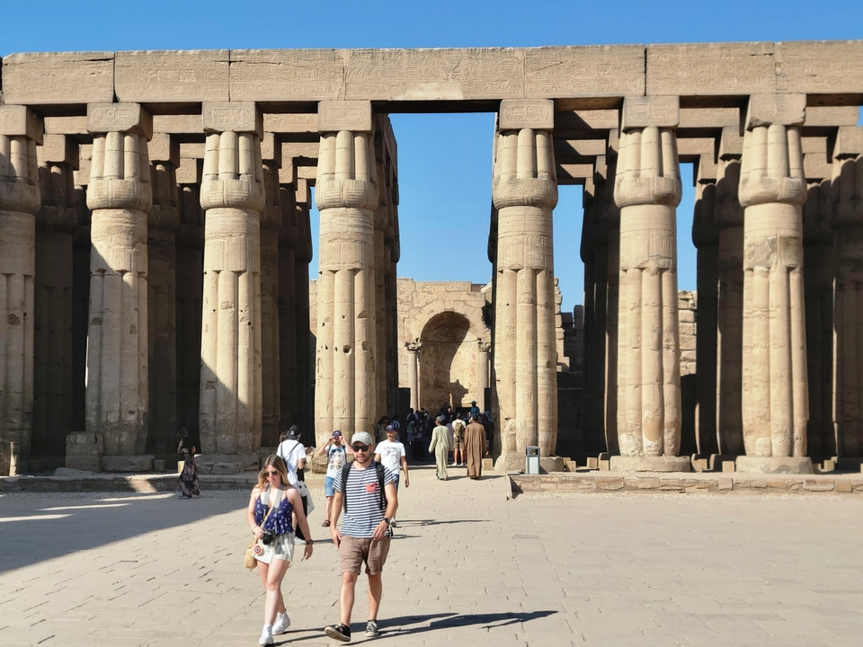 Colonnes historiques avec des personnes explorant le site.