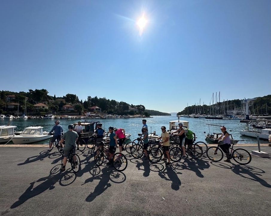 Groupe de personnes avec des vélos près d'un port de plaisance.
