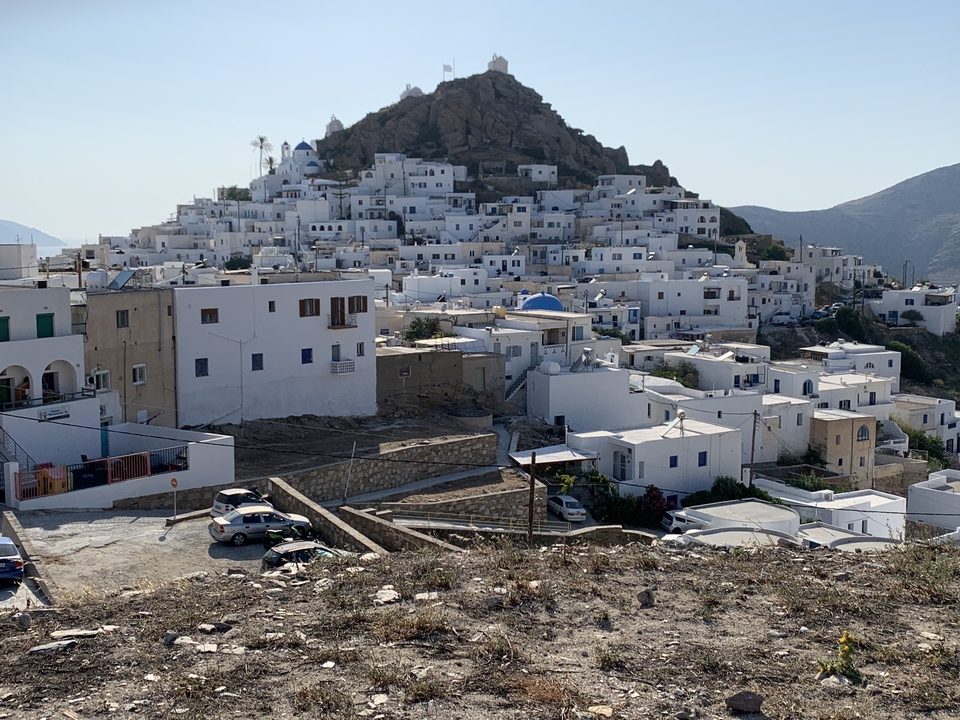 Whitewashed buildings on a hillside of a Greek island.