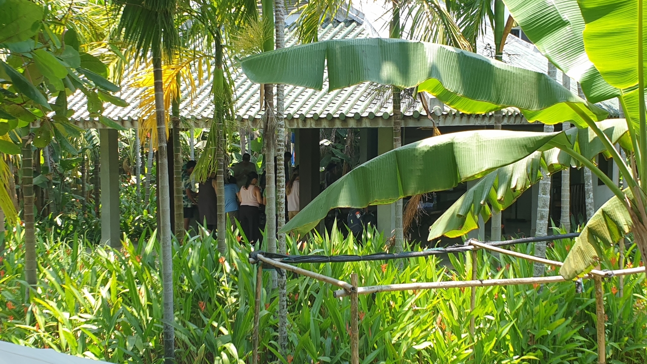 Tropical setting with people at a pavilion.