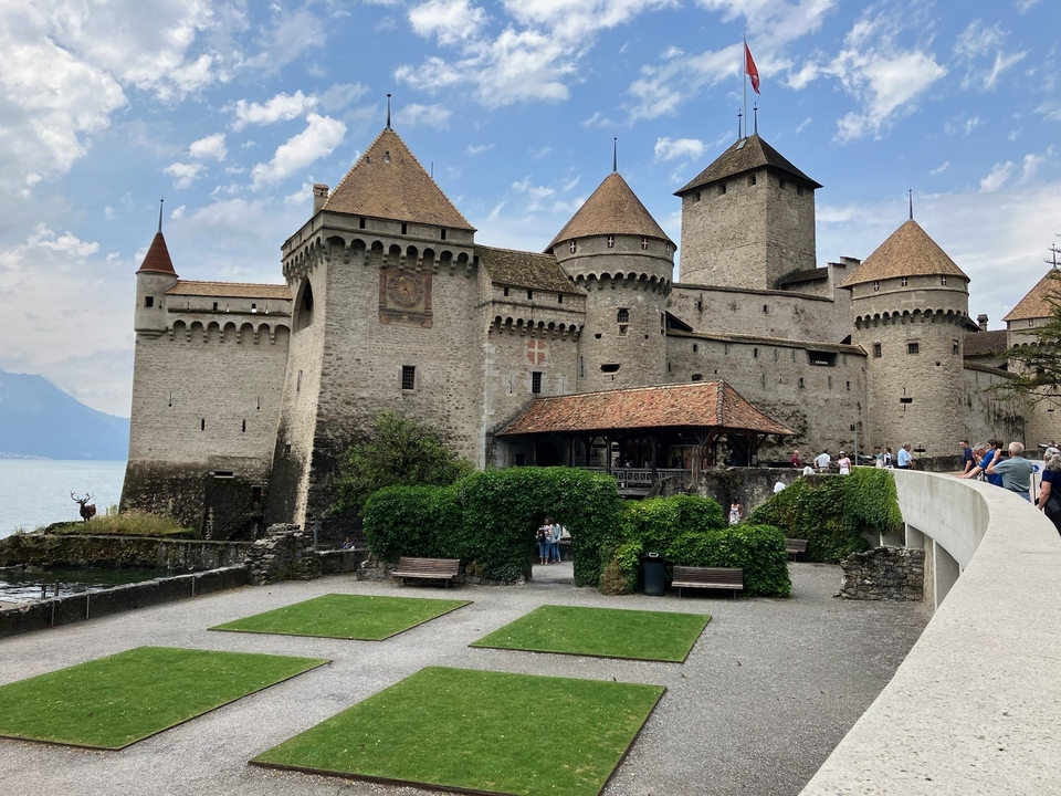 Château médiéval avec des touristes autour.