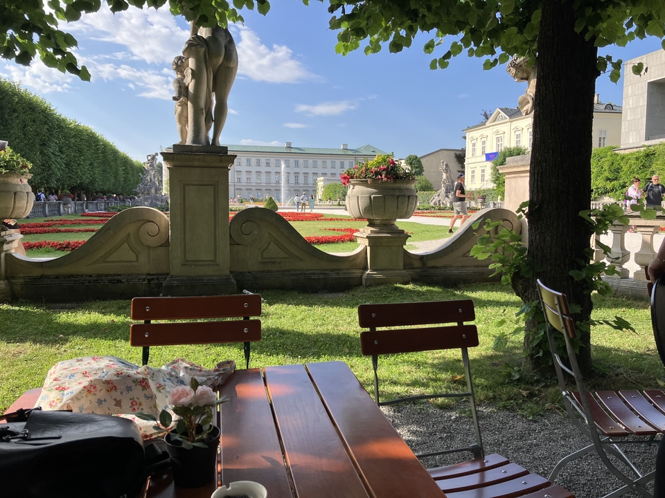 Jardin avec des bancs et un palais en arrière-plan.