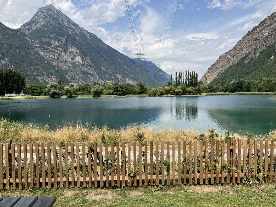 Vue panoramique d'un lac entouré de montagnes.