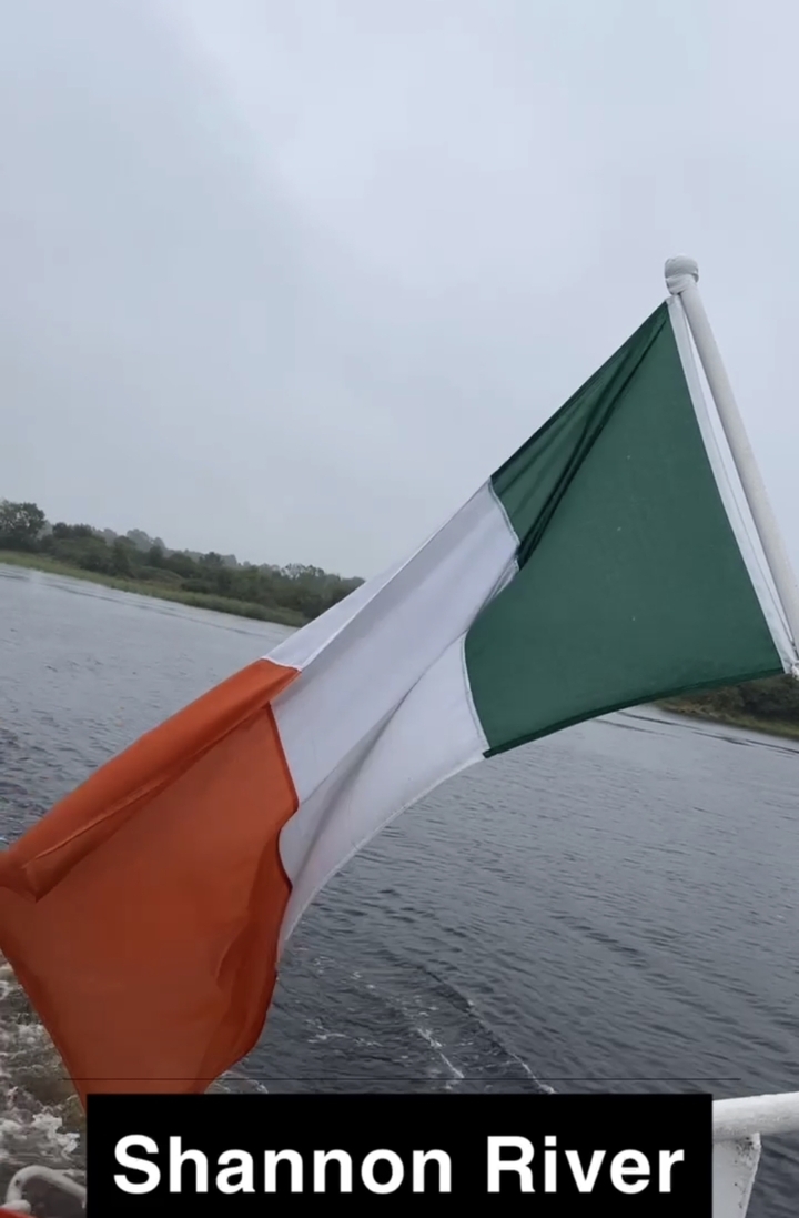Irish flag on a boat in a river.