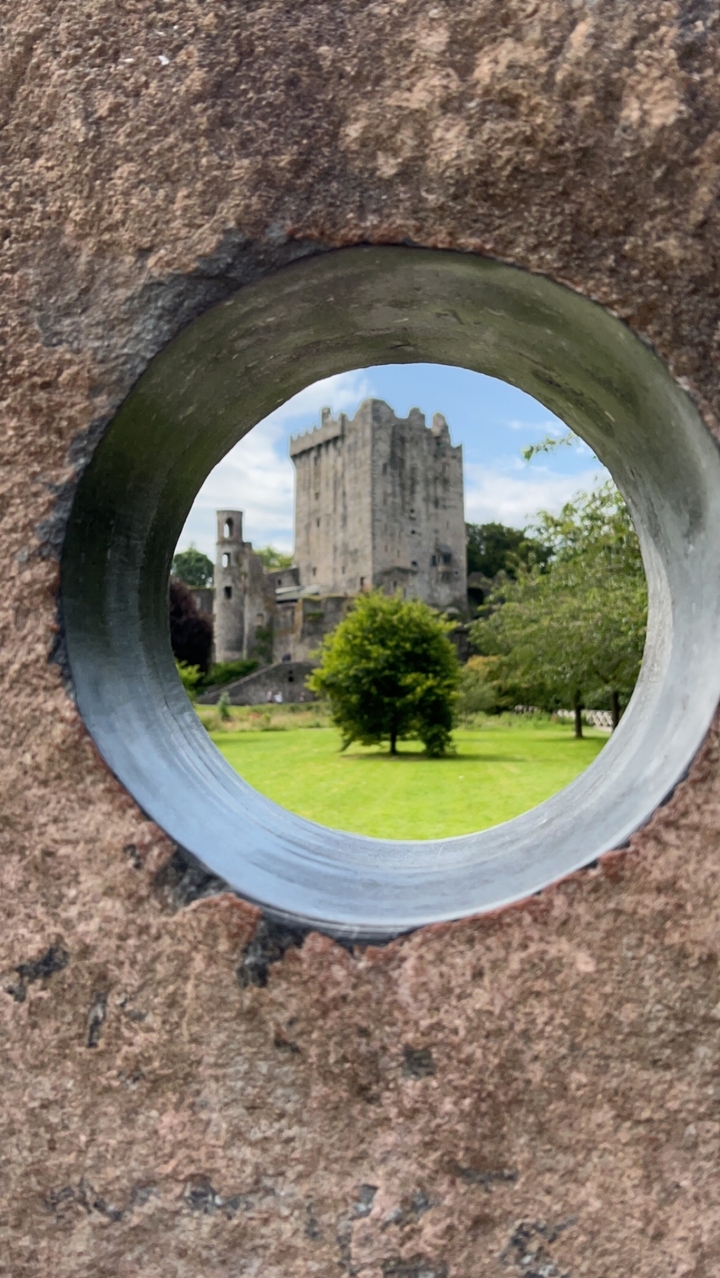 Castle viewed through a round opening in stone.