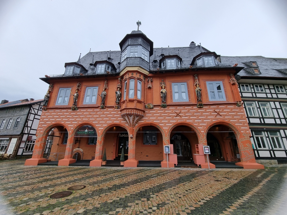 Un bâtiment historique aux couleurs vives avec des arches et des statues.