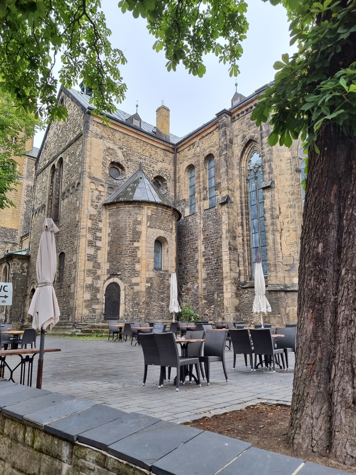 Un ancien bâtiment en pierre avec de hautes fenêtres et un patio.