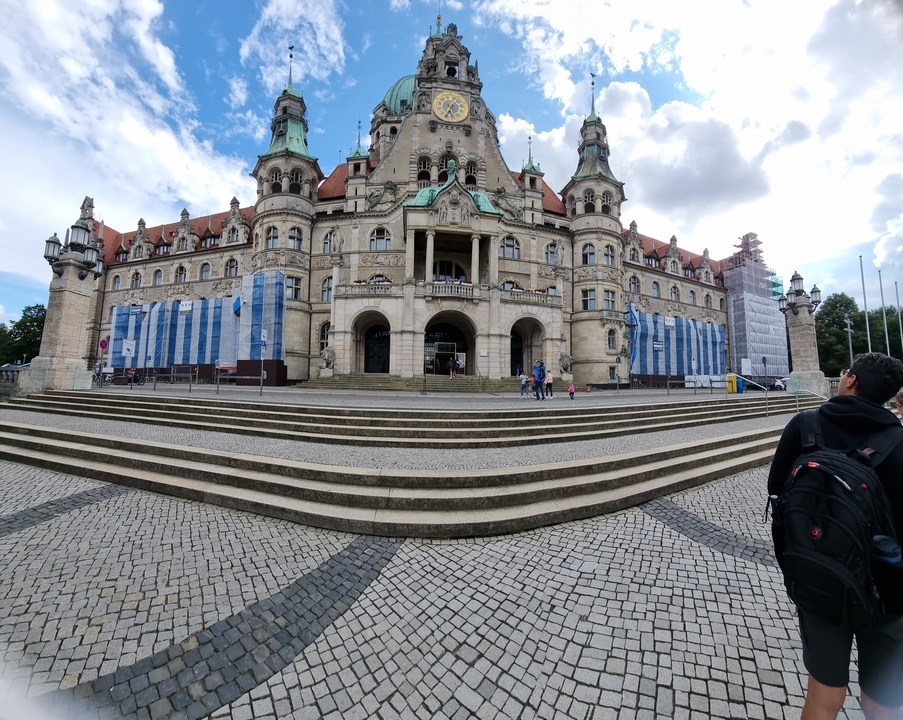 Un grand bâtiment gouvernemental en rénovation avec des gens qui marchent sur les marches.