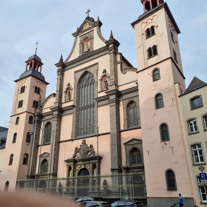 Une église historique avec des tours et un grand vitrail.