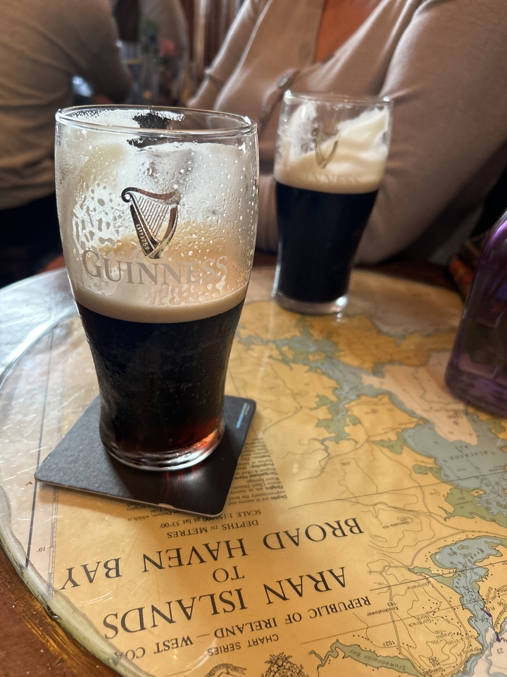 Une pinte de Guinness sur une table avec une carte en dessous.