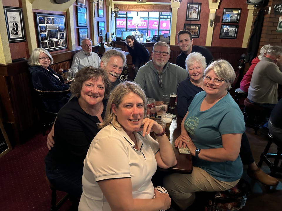 Un groupe de personnes savourant des boissons dans l'ambiance chaleureuse d'un pub.
