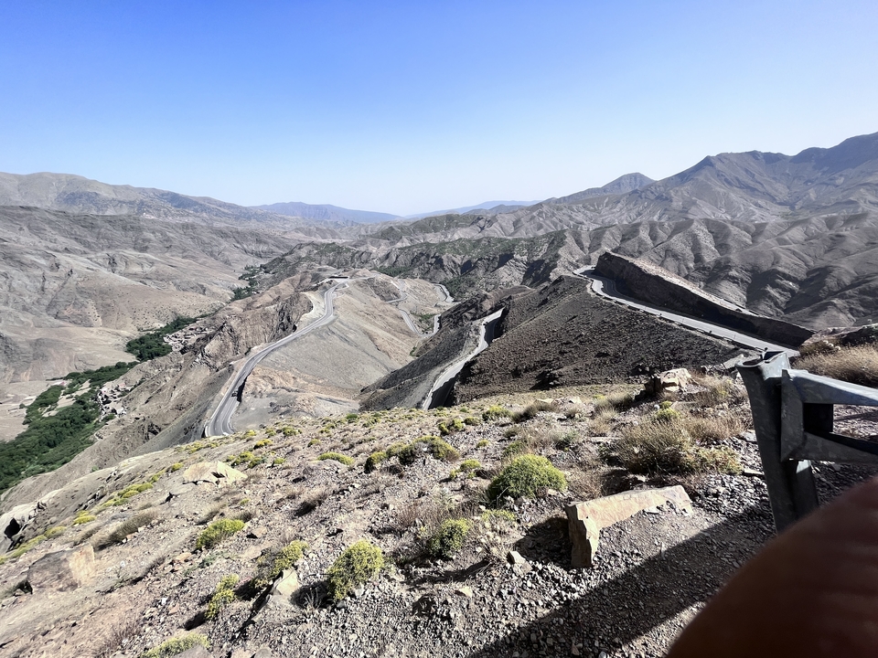A mountain pass with winding roads and rocky terrain.
