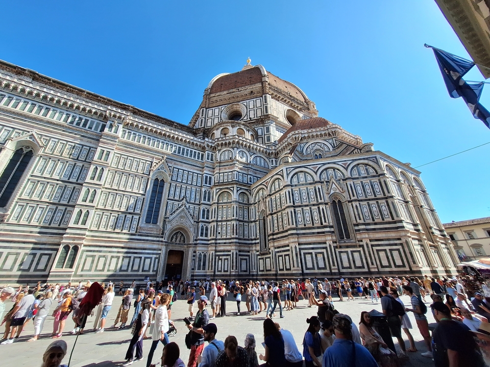Tourists at the Florence Cathedral in a crowded plaza.